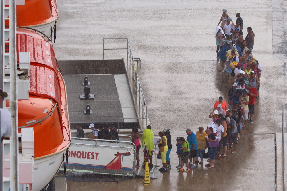 Cruise ship passengers stuck in a long line in the rain